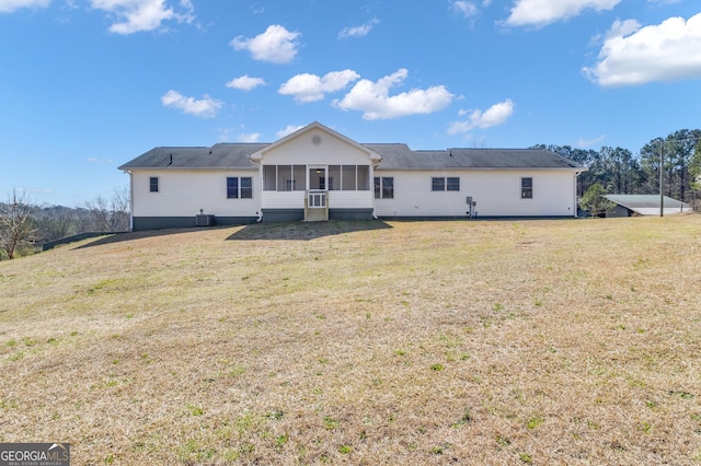 rear view of house with a yard and a sunroom