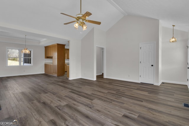 unfurnished living room featuring high vaulted ceiling, a raised ceiling, a ceiling fan, dark wood-style floors, and baseboards