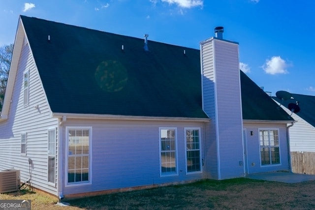 back of property featuring a patio, fence, cooling unit, a yard, and a chimney