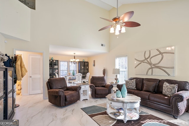 living area with vaulted ceiling, ceiling fan with notable chandelier, visible vents, and marble finish floor