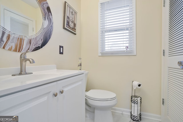 bathroom featuring baseboards, toilet, and vanity