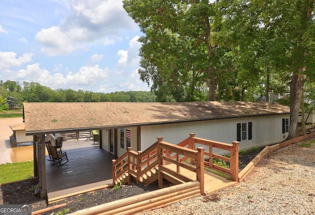 exterior space with a wooden deck and a shingled roof