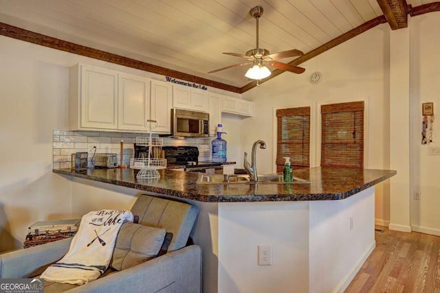 kitchen featuring light wood-style floors, stainless steel microwave, wooden ceiling, vaulted ceiling with beams, and black / electric stove