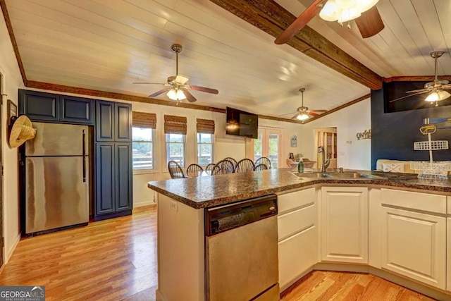 kitchen with a sink, ceiling fan, lofted ceiling with beams, and stainless steel appliances