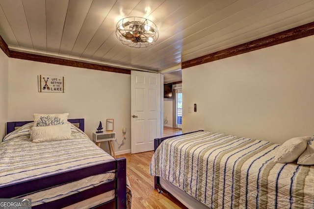 bedroom featuring crown molding and light wood-style flooring