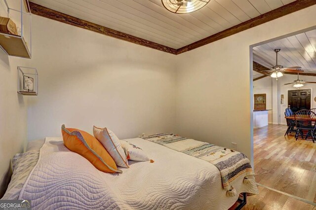 bedroom featuring light wood-style floors, ornamental molding, and wood ceiling