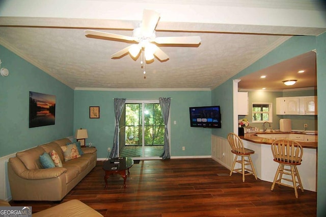 living area featuring ornamental molding, a textured ceiling, a ceiling fan, and wood finished floors