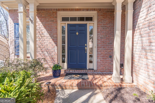 entrance to property featuring brick siding