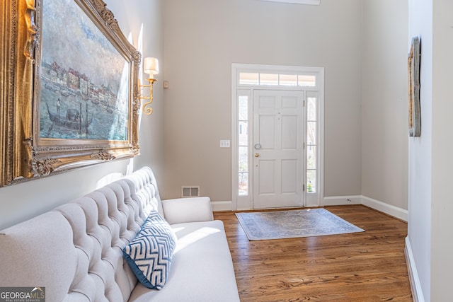 foyer featuring baseboards and wood finished floors