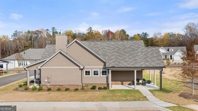 view of front of home with a chimney and a front lawn