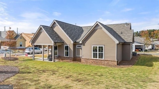 back of house featuring a lawn and brick siding