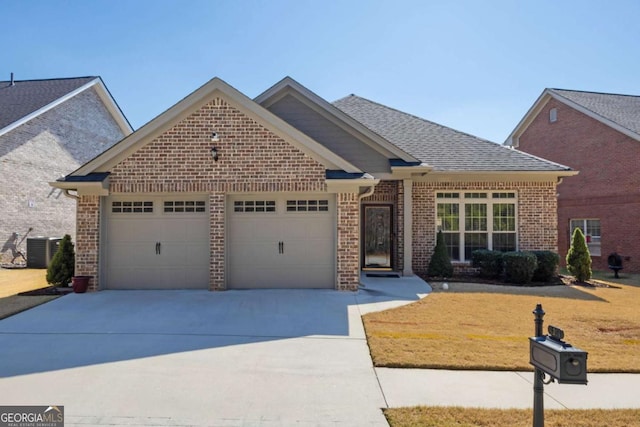 view of front of house featuring central AC, concrete driveway, an attached garage, a shingled roof, and brick siding