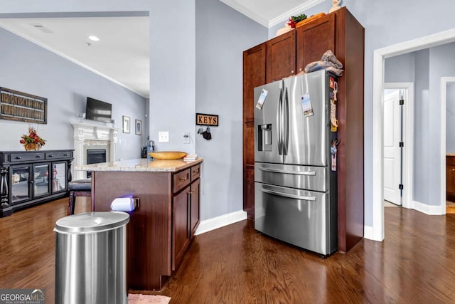 kitchen with dark wood-style floors, a peninsula, a fireplace, stainless steel fridge with ice dispenser, and crown molding