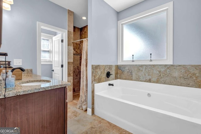 bathroom featuring tiled shower, a garden tub, and vanity