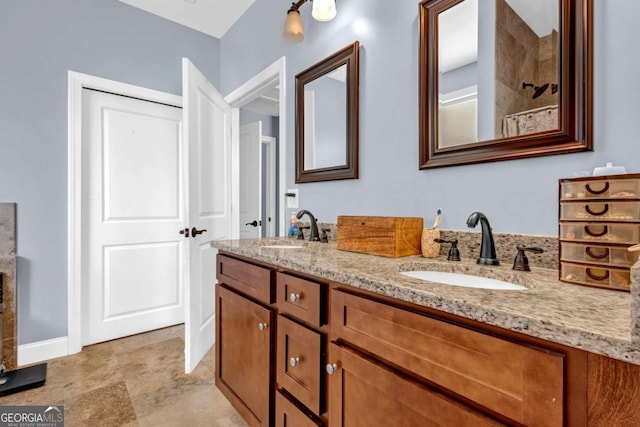 bathroom with double vanity, baseboards, and a sink