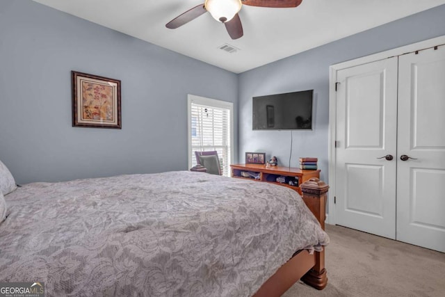 bedroom featuring light colored carpet, visible vents, a closet, and ceiling fan