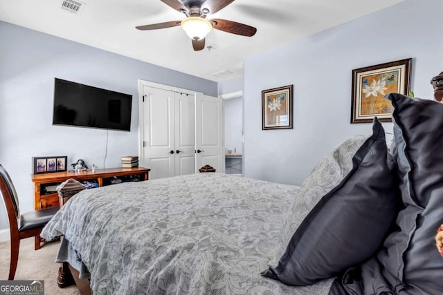 carpeted bedroom featuring visible vents, a closet, and ceiling fan