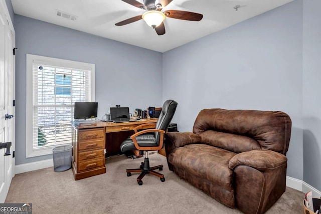 home office featuring visible vents, light carpet, baseboards, and a ceiling fan