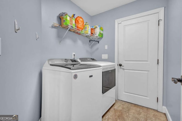 laundry room with laundry area, washing machine and dryer, and baseboards