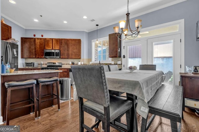 dining area with visible vents, a chandelier, light wood-type flooring, ornamental molding, and recessed lighting