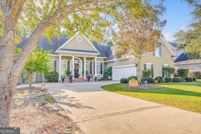 neoclassical home with a garage, stucco siding, concrete driveway, and a front yard