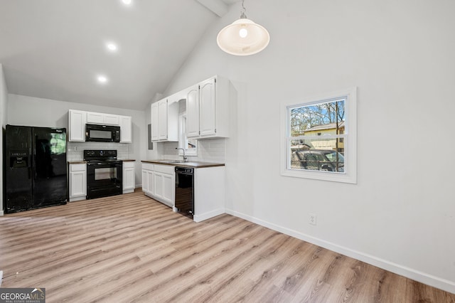 kitchen featuring black appliances, tasteful backsplash, white cabinetry, light wood-style floors, and baseboards