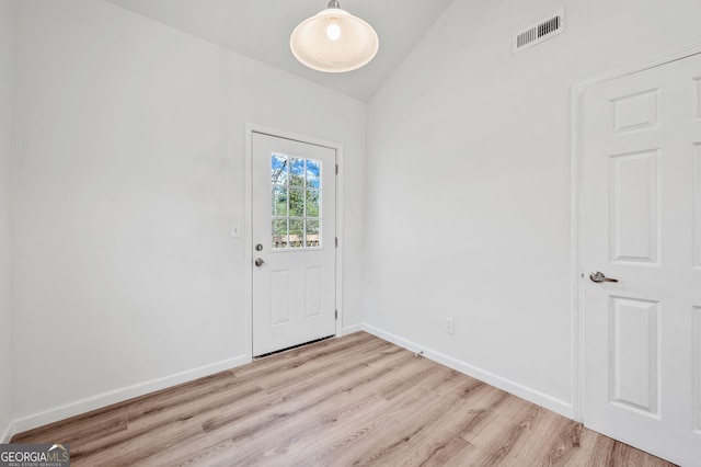 entrance foyer featuring light wood-type flooring, visible vents, lofted ceiling, and baseboards