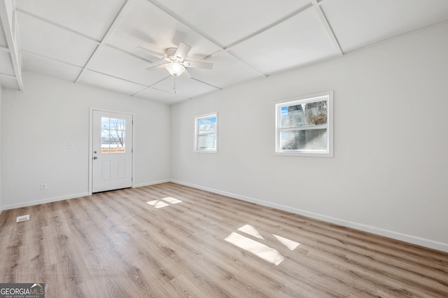 spare room with a paneled ceiling, baseboards, light wood-style floors, and a ceiling fan