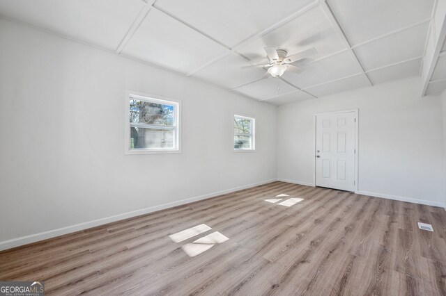 spare room with light wood-style flooring, a ceiling fan, and baseboards