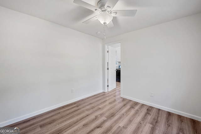 unfurnished room with baseboards, light wood-style floors, and a ceiling fan