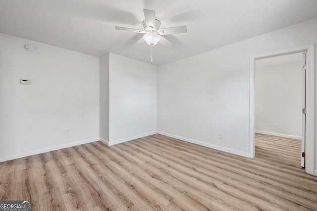 spare room with baseboards, a ceiling fan, and wood finished floors