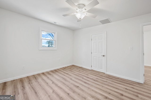 unfurnished room with visible vents, a ceiling fan, baseboards, and wood finished floors