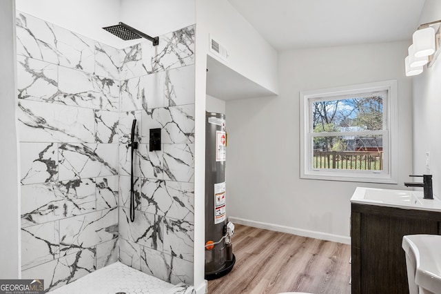 full bathroom featuring wood finished floors, water heater, a tile shower, baseboards, and vanity