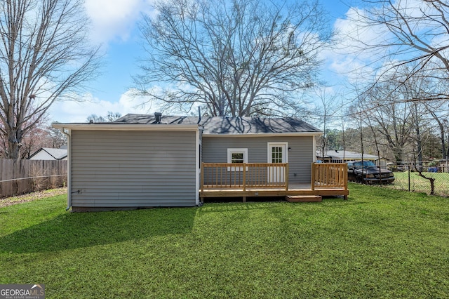 back of house featuring a yard, a wooden deck, and a fenced backyard