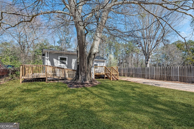 view of yard with a deck and fence