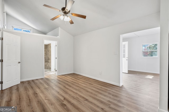 spare room featuring ceiling fan, baseboards, lofted ceiling, and light wood-style flooring