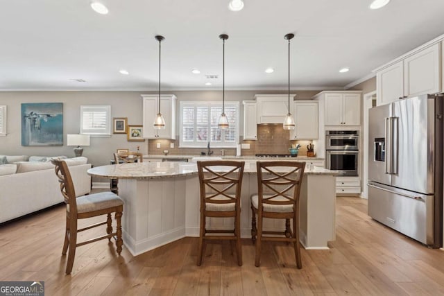 kitchen featuring white cabinets, light wood-type flooring, backsplash, and stainless steel appliances