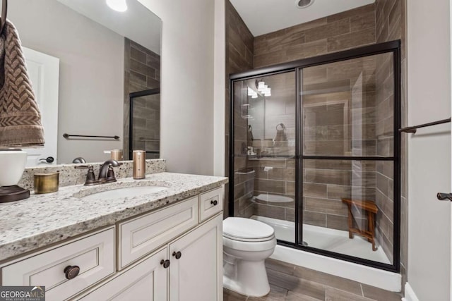 full bathroom featuring a shower stall, toilet, vanity, and wood finished floors