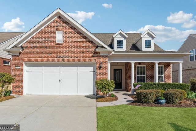 view of front facade with a garage, brick siding, a porch, and driveway