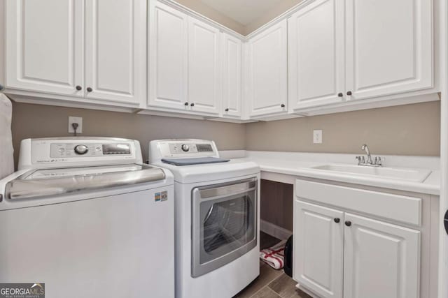 laundry area featuring dark wood-type flooring, cabinet space, independent washer and dryer, and a sink