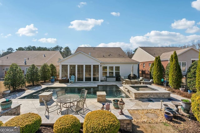 back of property featuring a patio, a fenced backyard, a sunroom, an outdoor pool, and an in ground hot tub