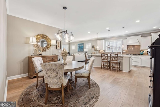 dining space with recessed lighting, light wood-style floors, baseboards, and ornamental molding