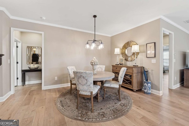 dining room featuring visible vents, light wood-type flooring, baseboards, and ornamental molding