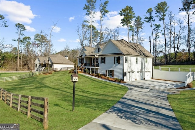 view of front facade featuring a front yard, fence, and driveway