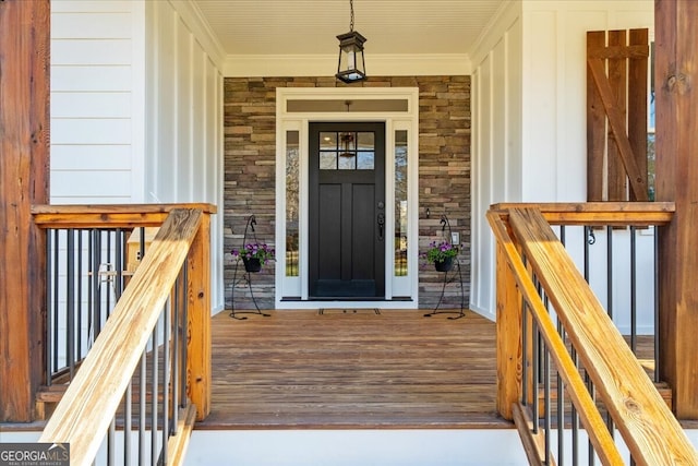 property entrance with stone siding and a porch