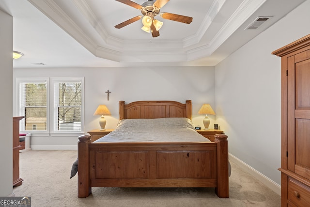 bedroom with a raised ceiling, light colored carpet, visible vents, and ornamental molding