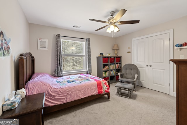 carpeted bedroom featuring visible vents, a closet, and ceiling fan