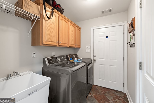 laundry room with a sink, visible vents, cabinet space, and independent washer and dryer