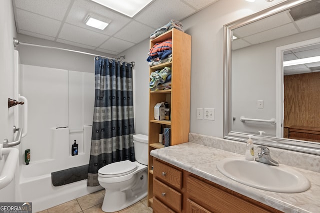 full bath featuring vanity, a drop ceiling, shower / tub combo, tile patterned floors, and toilet