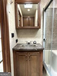 full bath featuring vanity and a shower with shower door